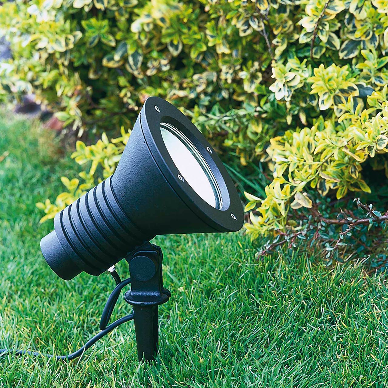 Eine LED-Strahler mit Erdspieß in einer Gartenanlage